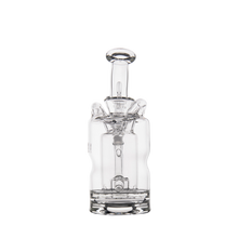 The MJ Arsenal Turbine Mini Dab Rig is a clear borosilicate glass water pipe featuring a cylindrical base, upright chamber, and detailed glass accents, shown against a plain white background.