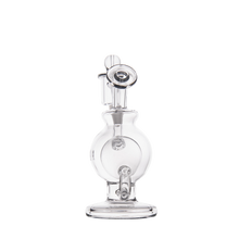 The MJ Arsenal Atlas Mini Dab Rig, made from clear borosilicate glass, features a round chamber, flat circular base, and curved mouthpiece. It is photographed against a plain white background.