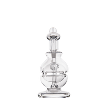 The MJ Arsenal Royale Mini Dab Rig is crafted from clear borosilicate glass with a rounded base, central chamber, angled mouthpiece, and a fab egg percolator. It’s shown against a plain white background.