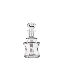 The MJ Arsenal Jammer Mini Dab Rig, made from clear borosilicate glass with an elegant, curvy design, is shown empty with a round stopper and photographed against a plain white background.