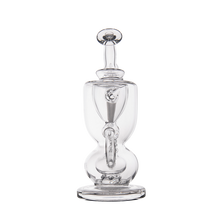 The MJ Arsenal Titan Mini Dab Rig, made of clear borosilicate glass with a round base, bulbous middle, and tall stopper on top, is displayed against a plain white background.