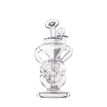 The MJ Arsenal Infinity Mini Dab Rig is a clear borosilicate glass water pipe featuring intricate, rounded designs and multiple chambers, shown standing upright against a plain white background.
