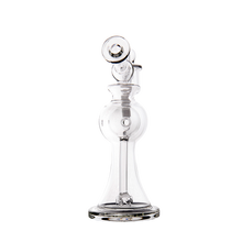 The MJ Arsenal Apollo Mini Dab Rig is a clear borosilicate glass water pipe with a round chamber, cylindrical neck, and flared base, designed for flavor preservation—perfect for dabbing. Shown against a plain white background.