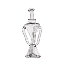 The MJ Arsenal Time Turner Mini Dab Rig is a clear borosilicate glass vessel shaped like an hourglass, featuring two angled side handles and a round top stopper, shown against a white background.