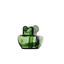 The MJ Arsenal Commander Blunt Bubbler is a modern, translucent green borosilicate glass piece with an abstract, sculptural design and two small round openings, reminiscent of a cone bubbler, shown against a plain white background.