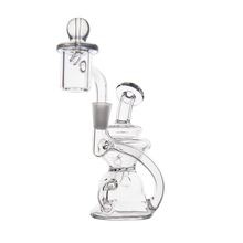 The MJ Arsenal Hydra Mini Dab Rig is a clear glass piece with a curvy Klein recycler design, cylindrical chamber, round base, and includes an attached quartz banger topped with a marble carb cap.