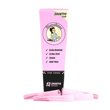 The Blazy Susan Pink Paper Cones come in a pink box labeled Shortys, containing 12 slow-burning, ultra-thin, vegan, GMO-free pre-rolled cones. Four pink cones are shown in front of the box.