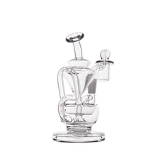 The MJ Arsenal Claude Mini Dab Rig is a clear glass recycler featuring a cylindrical base, curved tubes, upright mouthpiece, side bowl attachment, and multiple chambers with intricate glasswork inspired by the original Claude Mini Rig design.