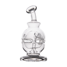 The MJ Arsenal Royale Vape Edition is a clear glass bottle featuring a sculpted face design, rounded body, and short angled neck with a circular top opening, inspired by the Royale Vape Edition dab rig and set on a thick, flat base.