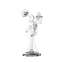 The MJ Arsenal Apollo Mini Dab Rig is a clear borosilicate glass piece with a round chamber, angled mouthpiece, and side-mounted bowl with fitted cap, crafted for optimal flavor preservation—all shown on a plain white background.