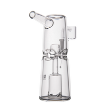 The MJ Arsenal Turret Mini Dab Rig features clear borosilicate glass with a cylindrical body, angled mouthpiece, and decorative glass accents around the center, shown against a white background.