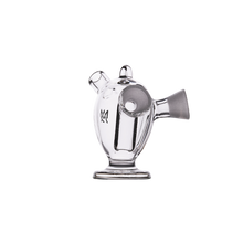 The MJ Arsenal Dubbler Original Double Bubbler is a clear borosilicate glass water pipe featuring a rounded body, two angled mouthpieces, and a sturdy circular base, shown against a plain white backdrop.