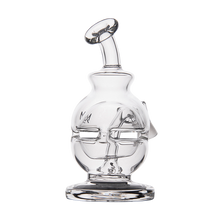 The MJ Arsenal Royale Vape Edition features a clear glass sculpture resembling a stylized human face with closed eyes, a tilted circular handle on top, and a round base, displayed against a white background.