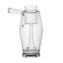 The MJ Arsenal Proxy Bubbler features a modern, transparent borosilicate glass body with a unique angular design and off-center handle, shown against a plain white background.