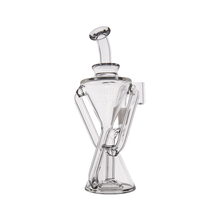 The MJ Arsenal Time Turner Mini Dab Rig is a clear borosilicate glass piece featuring an hourglass-shaped body, angled mouthpiece, and side chamber, photographed on a white background for a sleek and modern look.