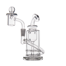 The MJ Arsenal Ursa Mini Dab Rig—a clear borosilicate glass rig with a cylindrical base, bent neck, side percolator, domed quartz banger, and glass carb cap—is displayed against a plain white background.
