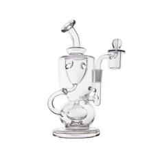 The MJ Arsenal Titan Mini Dab Rig is made of clear borosilicate glass and features a round base, curved neck, side handle, and an attached banger on the right, displayed against a white background.