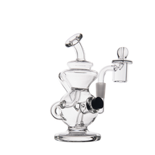 The MJ Arsenal Mini Jig Mini Dab Rig features clear glass, multiple curved chambers, a round base, a side mouthpiece, a vertical neck with loop handle, and a detachable glass attachment on the right.