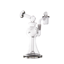 The MJ Arsenal Apollo Mini Dab Rig, made from durable borosilicate glass, features a dome-shaped base, bent neck mouthpiece, and an attached quartz banger for optimal flavor preservation against a plain white background.