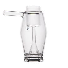 The MJ Arsenal Proxy Bubbler features clear borosilicate glass with a cylindrical base, wide body, vertical chamber, and angled side spout, creating a stylish dabbing accessory showcased on a white background.
