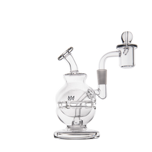 The MJ Arsenal Royale Mini Dab Rig is a clear borosilicate glass rig with a round base, bent neck, and includes an attached quartz banger and carb cap, shown isolated on a white background.