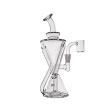 The MJ Arsenal Time Turner Mini Dab Rig is a clear borosilicate glass water pipe with an hourglass body, angled mouthpiece, and side arm for a bowl attachment, displayed against a plain white background.
