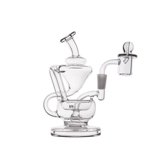 The MJ Arsenal Claude Mini Dab Rig is a clear glass recycler with intricate curved chambers, a cylindrical mouthpiece, detachable bowl, and stable round base, shown against a white background.