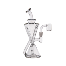 The MJ Arsenal Time Turner Mini Dab Rig is a clear borosilicate glass water pipe with a conical base, angled neck, cylindrical side chamber, intersecting glass tubes, and a flat round base for style and durability.