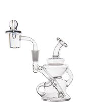 The MJ Arsenal Hydra Mini Dab Rig features a clear rounded base, bent neck, side handle, attached glass banger, and spherical carb cap. Its intricate curves and spill-resistant design are elegantly shown on a white background.