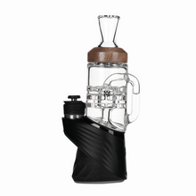 The MJ Arsenal Alpine Series - Halo Peak Top is a modern electronic dab rig with a borosilicate glass chamber, brown rim, and a sculpted black base featuring a side circular control.