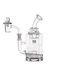 The MJ Arsenal Turbine Mini Dab Rig is crafted from clear borosilicate glass and features a curved mouthpiece, cylindrical body, side bowl, and a small front logo. Displayed against a plain white background.