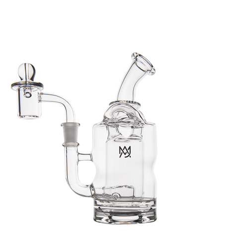 The MJ Arsenal Turbine Mini Dab Rig is crafted from clear borosilicate glass and features a curved mouthpiece, cylindrical body, side bowl, and a small front logo. Displayed against a plain white background.