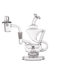The MJ Arsenal Claude Mini Dab Rig is a clear glass recycler with a complex, artistic design featuring multiple chambers, curved tubes, and a small bowl attachment, shown against a white background.