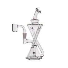 The MJ Arsenal Time Turner Mini Dab Rig is a clear borosilicate glass rig with an hourglass shape, bent mouthpiece, side arm for the bowl, and a visible spiral percolator inside.