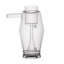 The MJ Arsenal Proxy Bubbler is a clear borosilicate glass accessory featuring a cylindrical chamber, side spout, and vertical tube—an elegant dabbing piece displayed against a white background.