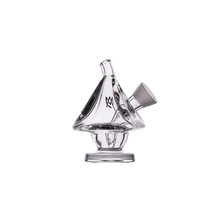The MJ Arsenal King Bubbler is a clear borosilicate glass piece shaped like a sailboat, with water filtration, a top mouthpiece, side bowl attachment, small pedestal base, and a black logo on the main body. Shown on a plain white background.