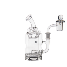The MJ Arsenal Turbine Mini Dab Rig is a clear borosilicate glass rig with a sidecar mouthpiece, cylindrical chamber, attached quartz banger with carb cap, and a modern design featuring the logo on its body.