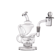 The MJ Arsenal Claude Mini Dab Rig is a clear glass recycler with multiple chambers, a curved neck, and a domed right-side attachment, all showcased against a plain white background.