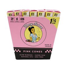 A pink box labeled Blazy Susan Pink Paper Cones contains 21 packs of 1 1/4 pre-rolled cones. The retro packaging features slow burning, super thin, naturally dyed, and GMO-free pink pre-rolled cones.