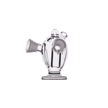 The MJ Arsenal Dubbler Original Double Bubbler, crafted from clear borosilicate glass, features a small, round vessel shape with a wide spout, circular side opening, and multiple top loops—resembling a modern artistic bubbler.