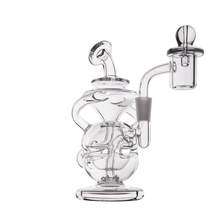 The MJ Arsenal Infinity Mini Dab Rig is a clear borosilicate glass water pipe featuring a curved neck, circular chamber, and side arm, designed for smoking or vaporizing substances. It is shown against a plain white background.