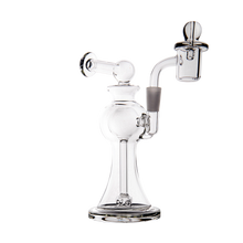 The MJ Arsenal Apollo Mini Dab Rig—made of clear borosilicate glass with a round base, angled mouthpiece, and quartz banger—is shown on a plain white background, crafted for optimal flavor preservation.