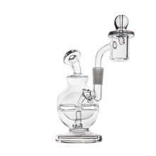 The MJ Arsenal Royale Mini Dab Rig, made of clear borosilicate glass with a round base, curved neck, and quartz banger, stands upright on a flat surface against a white background.
