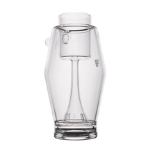 The MJ Arsenal Proxy Bubbler features a handleless, clear borosilicate glass body with a unique integrated stirring mechanism, cylindrical neck, and wide angular base—all in transparent glass for a modern look.