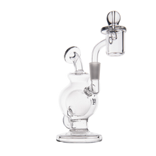 The MJ Arsenal Atlas Mini Dab Rig features clear borosilicate glass, a round base, bent neck, and side quartz banger. Compact and stylish, it’s functional for dabbing—shown here against a plain white background.
