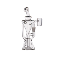 The MJ Arsenal Time Turner Mini Dab Rig is a clear borosilicate glass water pipe with a beaker base, curved neck, and side bowl, designed for smoking or vaporizing.