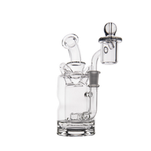 The MJ Arsenal Turbine Mini Dab Rig is a clear borosilicate glass water pipe with a cylindrical base, angled mouthpiece, removable bowl, and both curved and straight glass elements for smoking or vaporizing herbs or concentrates.