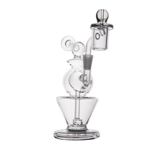 The MJ Arsenal Gemini Mini Dab Rig, made of clear borosilicate glass with a circular base, spherical chamber, angled mouthpiece, and decorative loops, is shown on a white background.