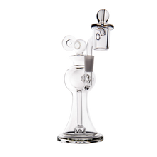 The MJ Arsenal Apollo Mini Dab Rig, made of clear borosilicate glass with a wide base, curved neck, and attached bowl, is shown against a plain white background—designed to preserve optimal flavor.