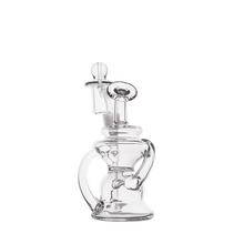 The MJ Arsenal Hydra Mini Dab Rig is a clear glass water pipe with a unique curvy design inspired by the Klein recycler style. It features a round base, angled mouthpiece, and cylindrical percolator chamber against a plain white background.